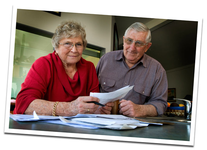 older man and woman looking at forms and bills