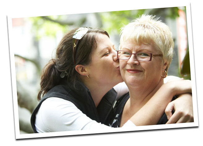 Young woman kissing older woman Young woman kissing older woman