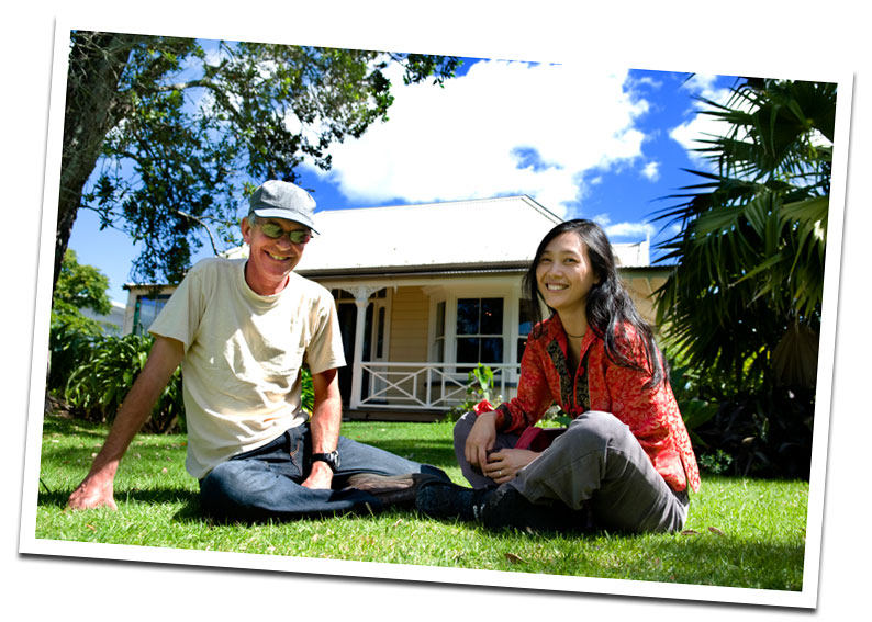 Old man and young woman sitting on lawn in front of house man and young woman sitting on lawn in front of house